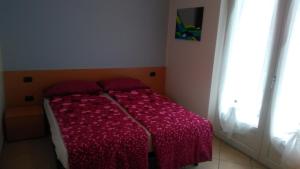 a small bedroom with a bed with a red blanket at Casa Torboli 2 in Arco