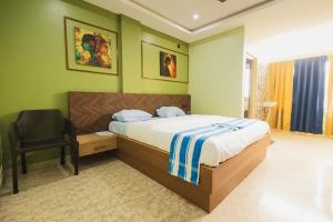 a bedroom with a bed and a chair at Lotus Leaf GuestHouse in Guwahati