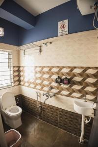 a bathroom with a toilet and a sink at Lotus Leaf GuestHouse in Guwahati +27 photos