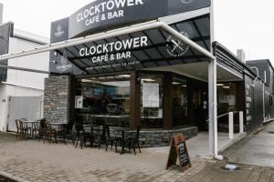 a cafe and bar with tables and chairs in front of it at Clock Tower Accommodation in Hokitika