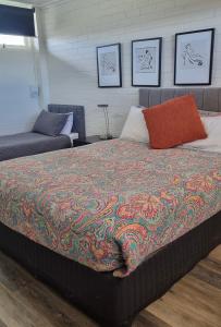 a bed with a colorful blanket on top of it at Dalby Parkview Motel in Dalby +169 photos
