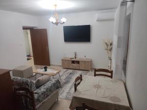 a living room with a couch and a tv on the wall at Oremari Home in Korçë