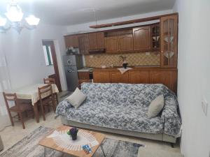a living room with a couch and a kitchen at Oremari Home in Korçë