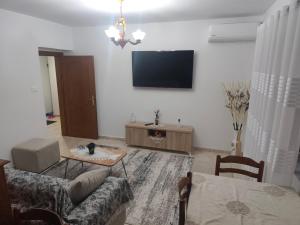 a living room with a couch and a tv on the wall at Oremari Home in Korçë