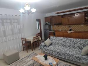 a living room with a couch and a table and a kitchen at Oremari Home in Korçë