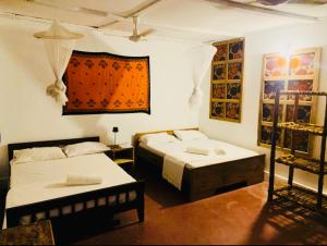 a room with two beds and a table in it at Paje lounge in Paje