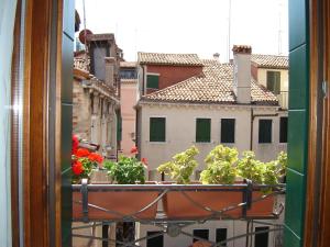 a view from a window with flowers on a balcony at Locanda Correr in Venice