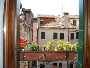 a view from a window with flowers on a balcony at Locanda Correr in Venice