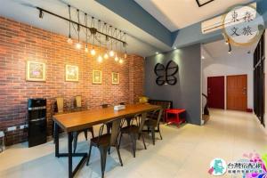 a dining room with a wooden table and a brick wall at 蝴蝶結溜滑梯親子民宿-寵物友善-無門禁24小時進出-免費停車-東森文旅-包棟優惠中 in Yuanshan