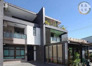 a black and white building with a sign on it at 蝴蝶結溜滑梯親子民宿-寵物友善-無門禁24小時進出-免費停車-東森文旅-包棟優惠中 in Yuanshan