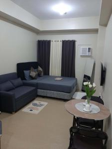 a living room with a couch and a table at The Suite Pod I CDO CondoStaycation - U26 in Cagayan de Oro