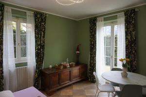 a living room with a table and chairs and windows at Dimora degli Gnomi in Tirano