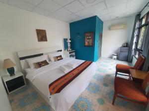 a bedroom with a large bed with a blue wall at Forge boutique in Chiang Mai