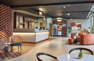 a lobby of a restaurant with tables and chairs at Leonardo Hotel Dublin Christchurch in Dublin