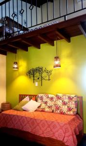 a bedroom with a couch with a yellow wall at CHALÉS DE SÃO JoSÉ in Tiradentes