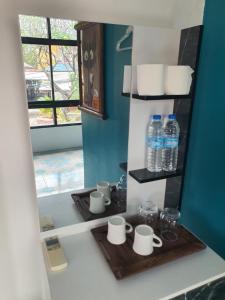 a kitchen counter with a tray with cups and water bottles at Forge boutique in Chiang Mai