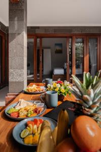 a table with three plates of food on it at Villa Mesari Bona in Blahbatu