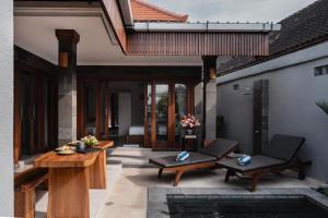 a patio with two chairs and a table at Villa Mesari Bona in Blahbatu