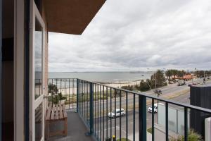 a balcony with a view of the ocean at St Kilda absolute beachfront views in Melbourne