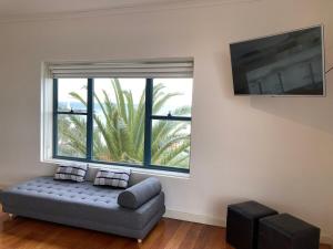 a living room with a couch and a large window at St Kilda absolute beachfront views in Melbourne