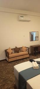 a room with two beds and a couch and a piano at Loveena by H.S. Restaurant & Guest in Tangalle