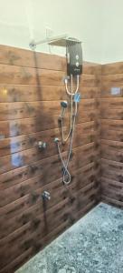 a shower in a bathroom with a wooden wall at Loveena by H.S. Restaurant & Guest in Tangalle +72 photos