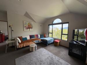 a living room with a couch and a window at Sun Views Forest yet close to town in Queenstown