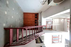 an empty room with a staircase and a wooden door at Matrika Rooms in Lucknow