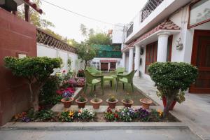 a courtyard with a table and chairs and flowers at Matrika Rooms in Lucknow