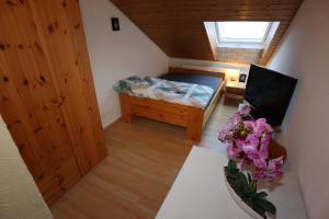 a small bedroom with a bed and a vase of flowers at Doppelzimmer Schwarzwaldharmonie mit gem. Küche in Todtmoos