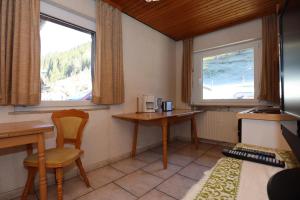 a room with two tables and two windows and a desk at Doppelzimmer Schwarzwaldharmonie mit gem. Küche in Todtmoos