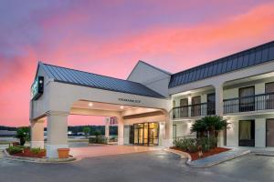a large building with a sunset in the background at Quality Inn Foley - Gulf Shores North in Foley