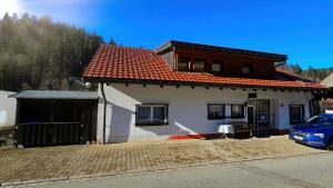 a house with a car parked in front of it at Doppelzimmer Schwarzwaldharmonie mit gem. Küche in Todtmoos
