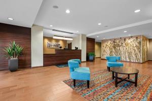 a lobby with blue chairs and a table at Sleep Inn & Suites Jasper I-22 in Jasper +49 photos