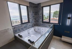 a large bathroom with a tub with windows at Safir Termal & Spa Otel in Çekirge İstasyonu +31 photos