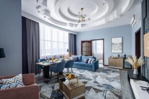 a living room with a blue couch and a table at Monotel Hotel in Ustʼ-Kamenogorsk