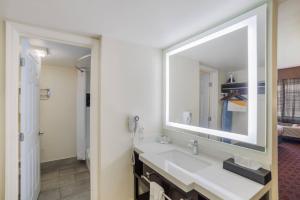 a bathroom with a sink and a large mirror at Quality Inn & Suites Goodyear - Phoenix West in Goodyear