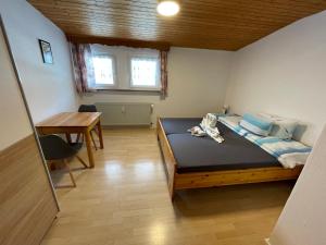 a small bedroom with a bed and a table at Ferienwohnung Wehra in Todtmoos in Todtmoos