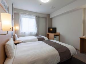 a hotel room with two beds and a television at Comfort Hotel Akita in Akita +25 photos