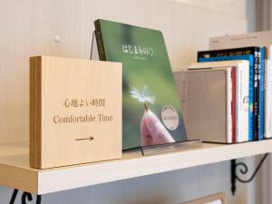 a book sitting on a shelf with books at Comfort Hotel Akita in Akita