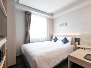 a hotel room with a bed and a window at Comfort Hotel Nagoya Shinkansenguchi in Nagoya