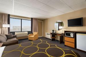 a hotel room with a bed a desk and a tv at Super 8 by Wyndham Hearst ON in Hearst