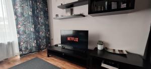a living room with a flat screen tv on a black entertainment center at Sunny Central Apartment in Sofia +54 photos
