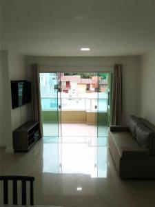 sala de estar con sofá y puerta corredera de cristal en Mediterraneo Home Club, en Bombinhas