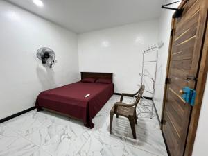 a small bedroom with a bed and a chair at Aathi Villas in Jaffna