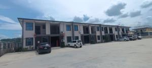 a large building with cars parked in a parking lot at Capital Transit Hub in Port Moresby