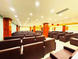 an empty lecture hall with brown chairs and tables at Hotel Ranjana Palace in Pūrnia