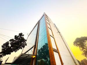 a glass building with a reflection of a tree at Hotel Ranjana Palace in Pūrnia