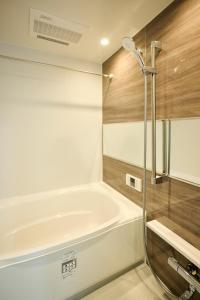 a bathroom with a bath tub and a shower at CREST Nishijin by Tranova in Fukuoka +4 photos