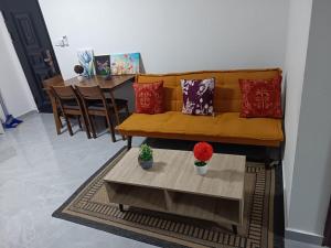 a living room with a yellow couch and a table at Capital Transit Hub in Port Moresby